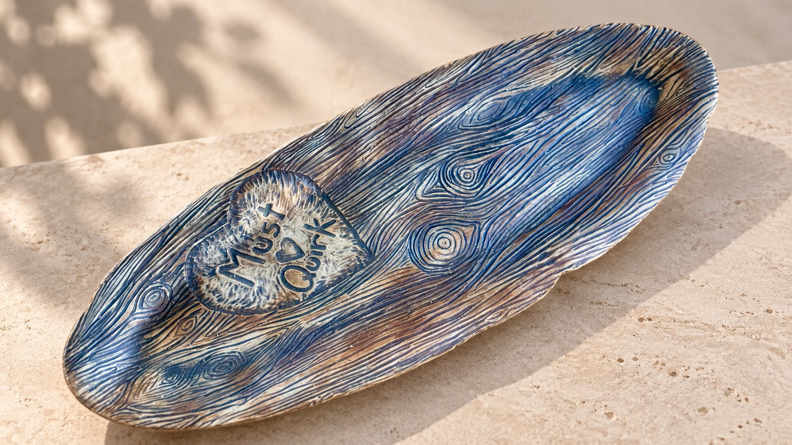 Blue and cream ceramic tray with carved woodgrain texture and a heart-shaped LoveQuirk detail
